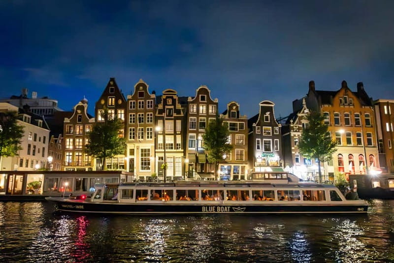 Canal houses lit at dusk along an Amsterdam canal